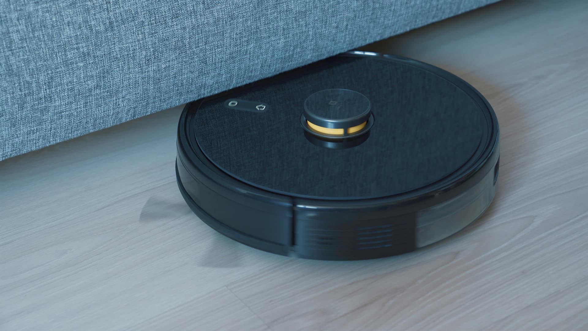Robot vacuum cleaner on floor with person relaxing on sofa